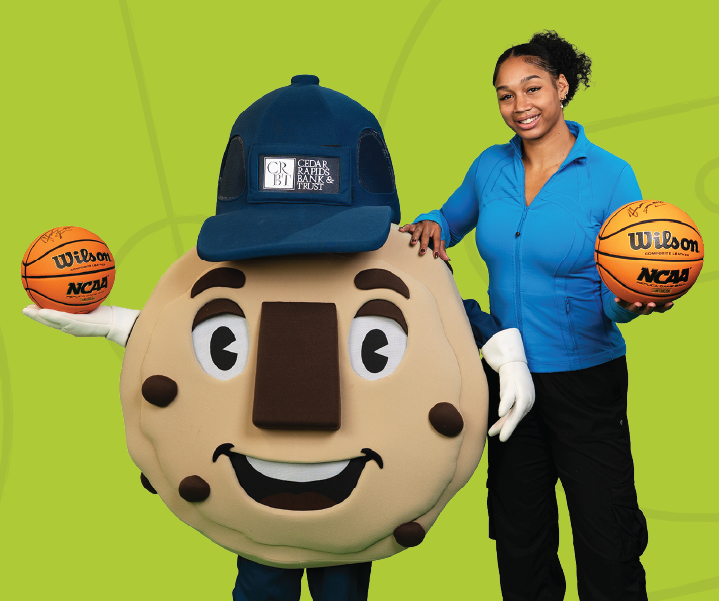 Hannah Stuelke posing with CRBT cookie mascot with a green background
