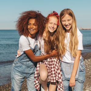 Three teenage girls smiling at the camera.